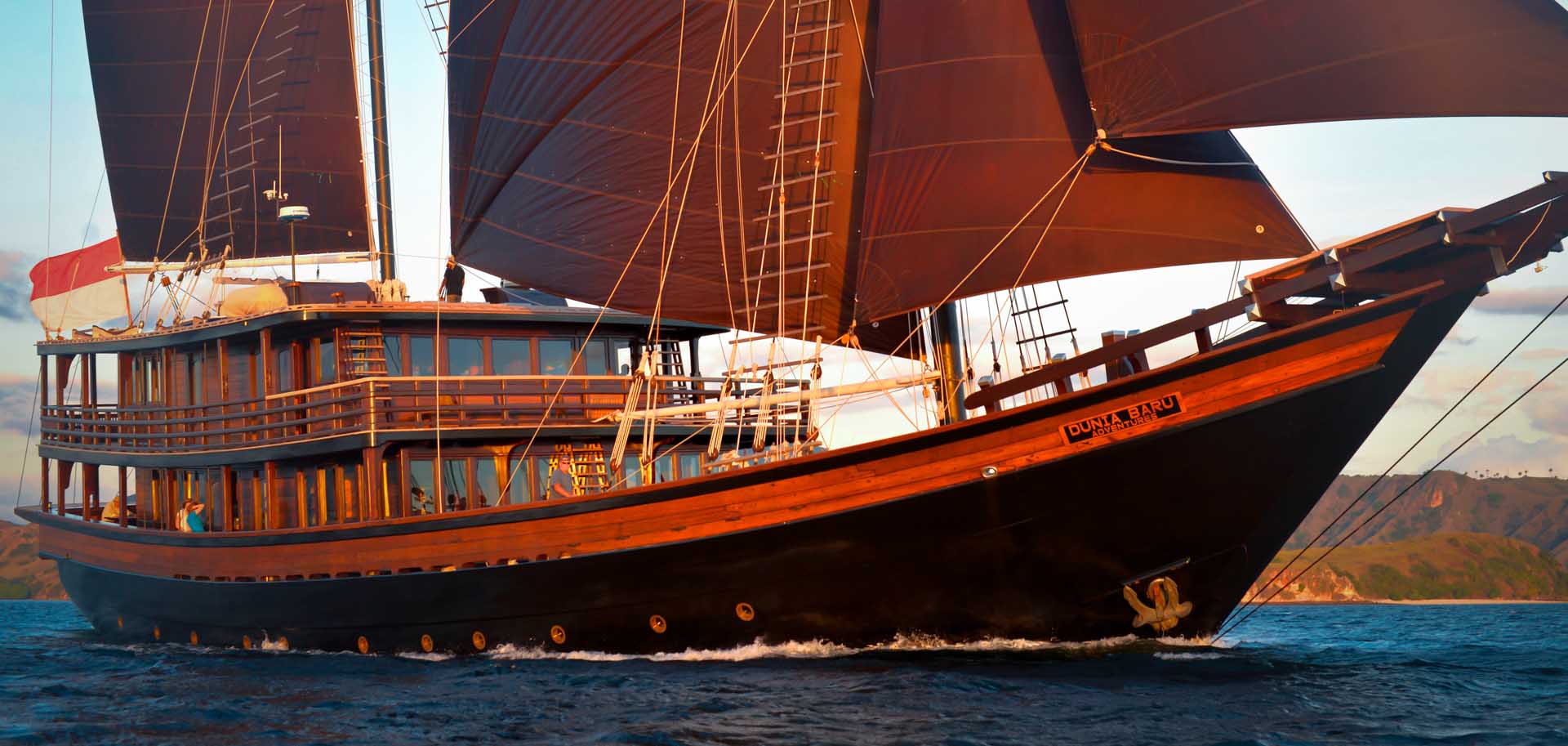 Dunia Baru with its sails out during golden hour