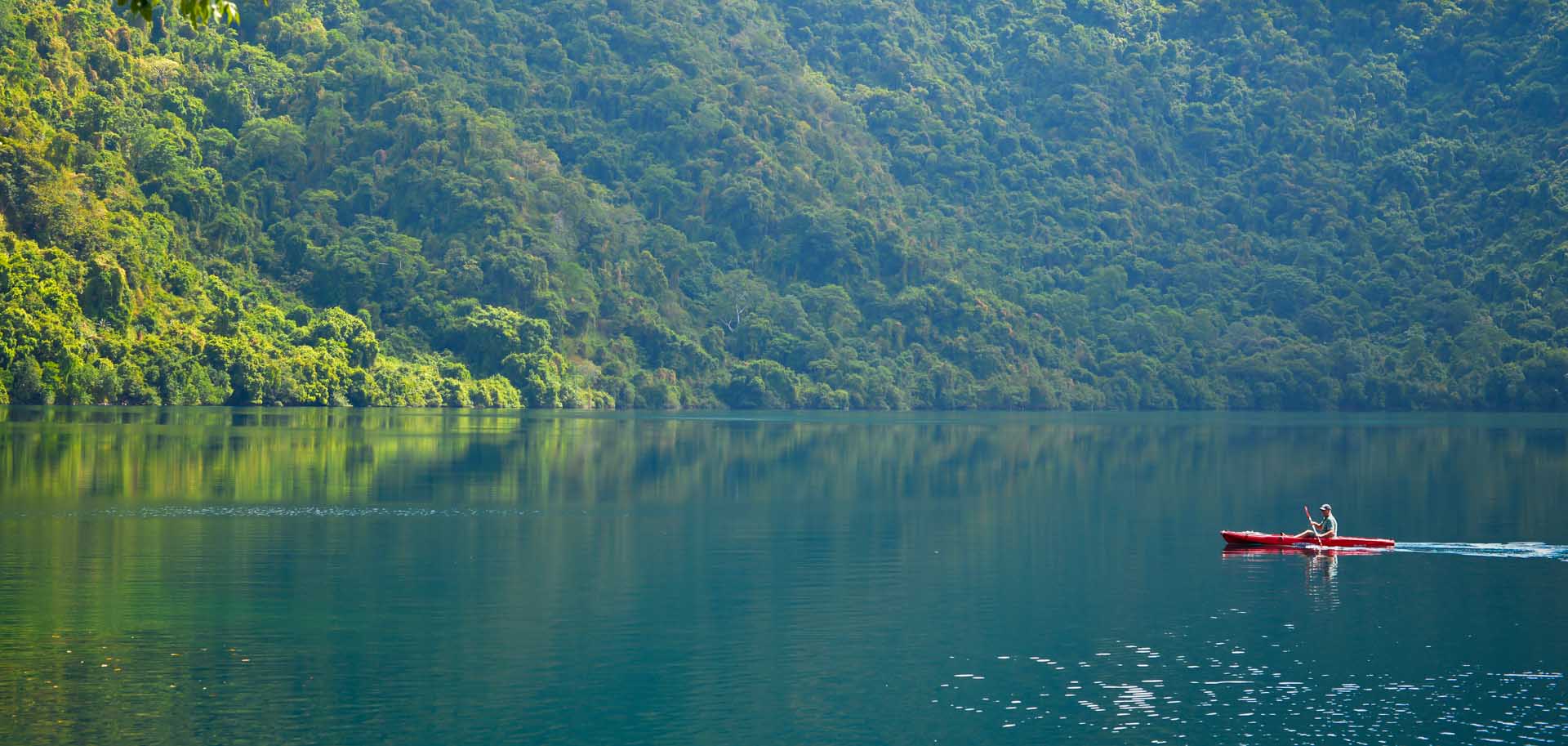 A man in a red canoe rowing on Satonda Island Crater Lake