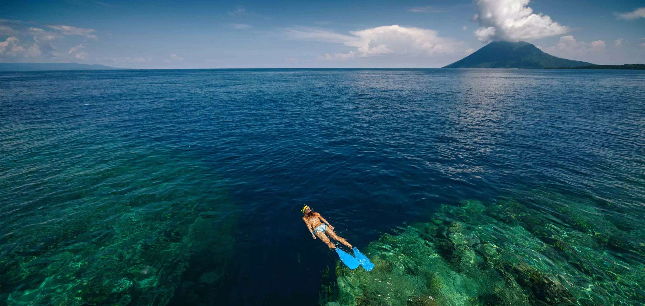 A woman snorkelling in crystal clear waters of North Sulawesi