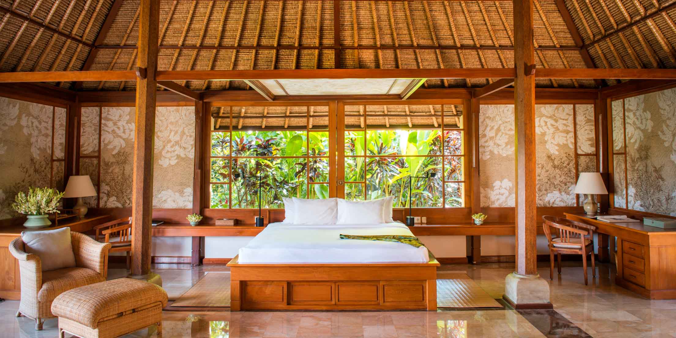 Wooden suite bedroom with a white bed inside a luxury resort
