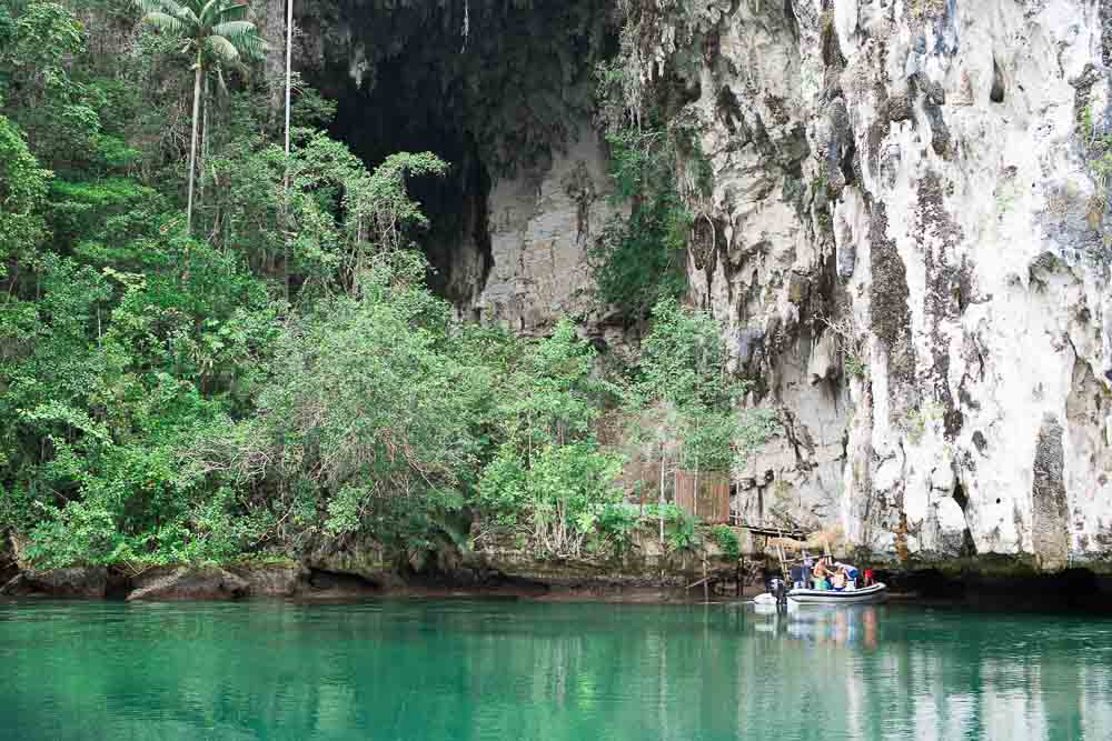 Yacht charter clients on a RIB, exploring the rocky mountain walls and caves of Misool