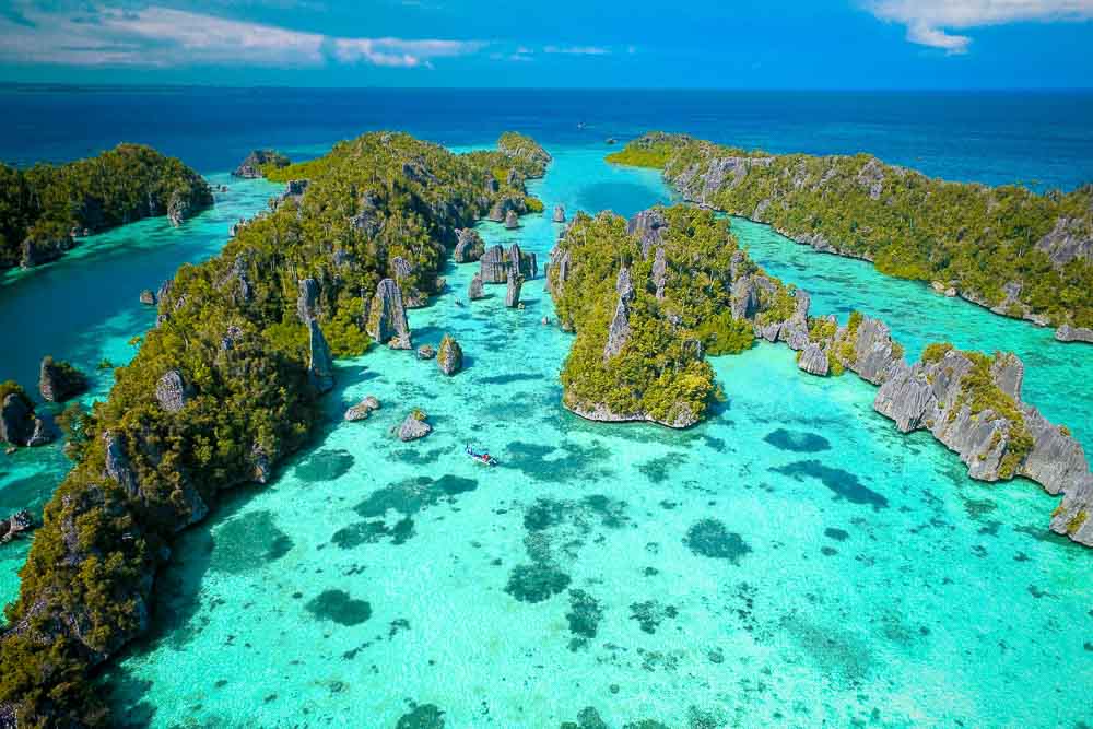 Aerial view on Wayag’s pristine turquoise waters and rocky islands covered with forest