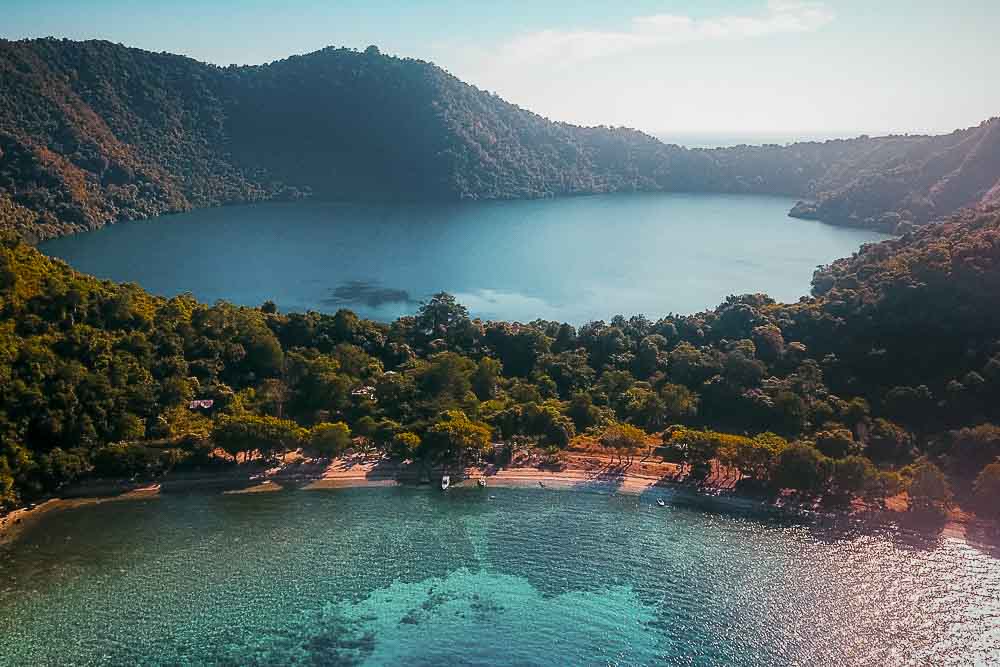 Aerial view on the island of Satonda, with green hills and a salt lake located in the middle of the island