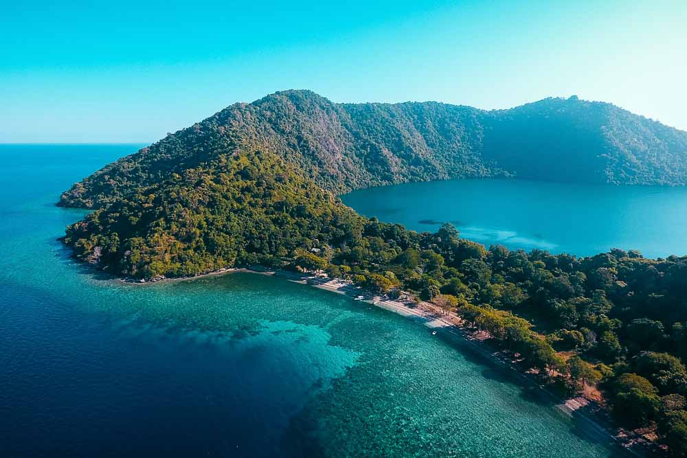 Aerial view on the island of Satonda, with green hills and a salt lake located in the middle of the island