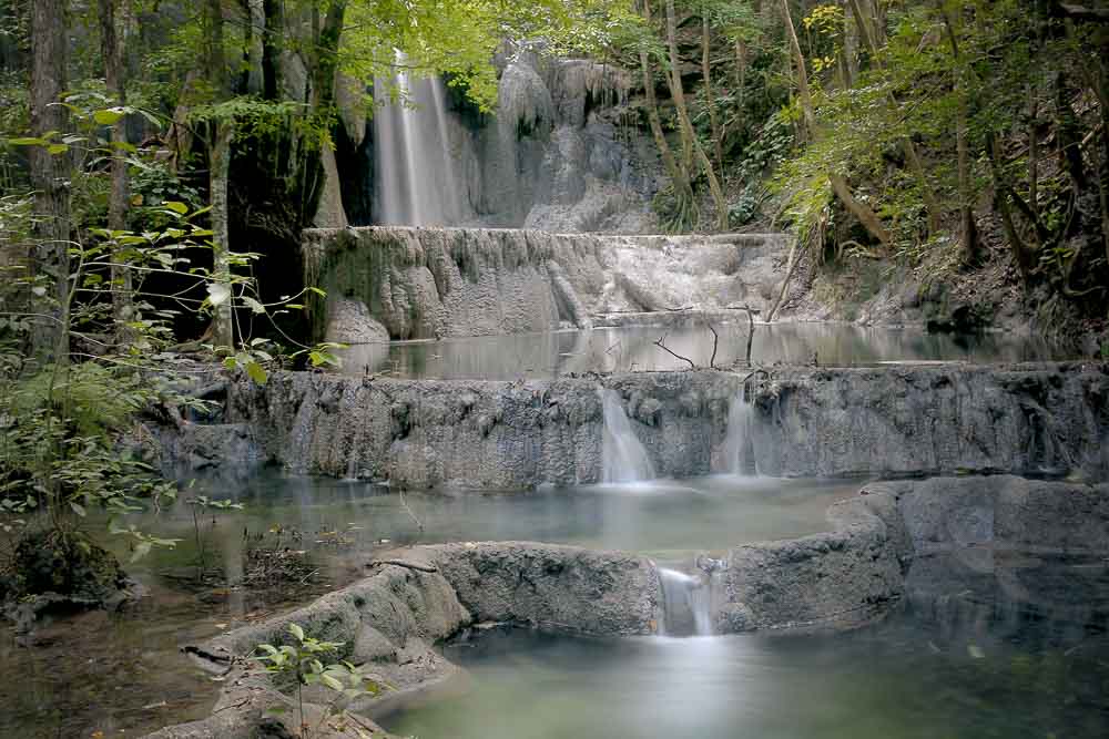 Long exposure shot of a waterfall among green trees