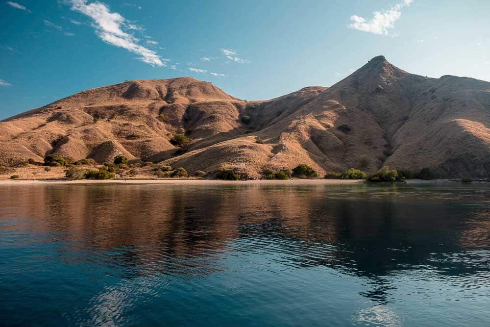 View on Komodo National Park's hilly island from the water during dry season