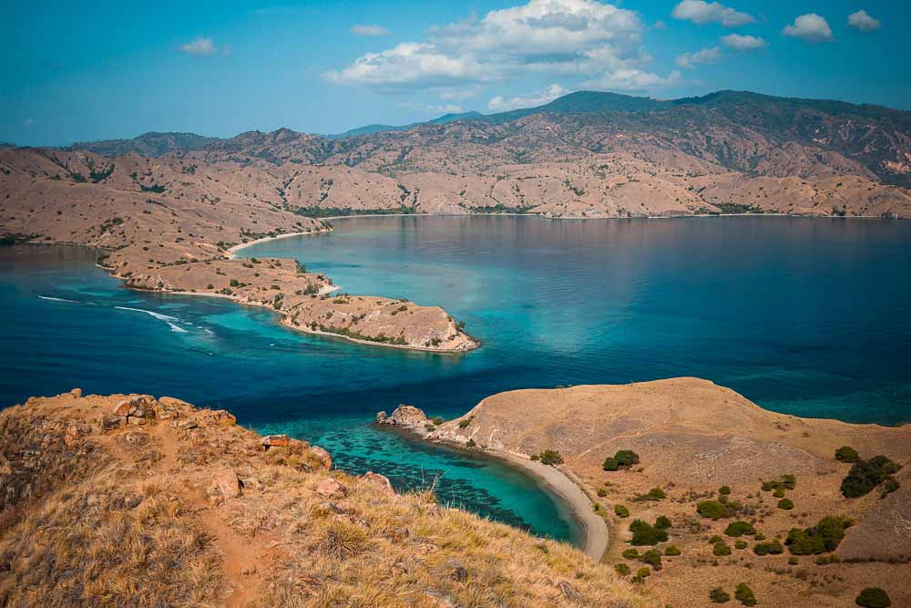 Aerial view on Komodo Island's dried hills and blue waters surrounding it