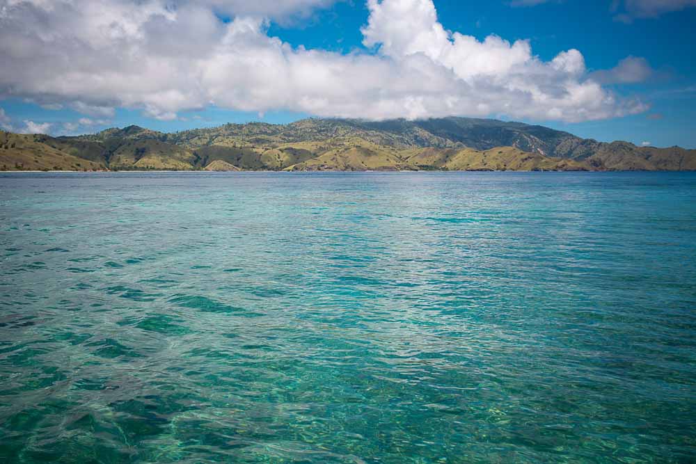 Turquoise waters and Gili Lawa island with green hills in the background