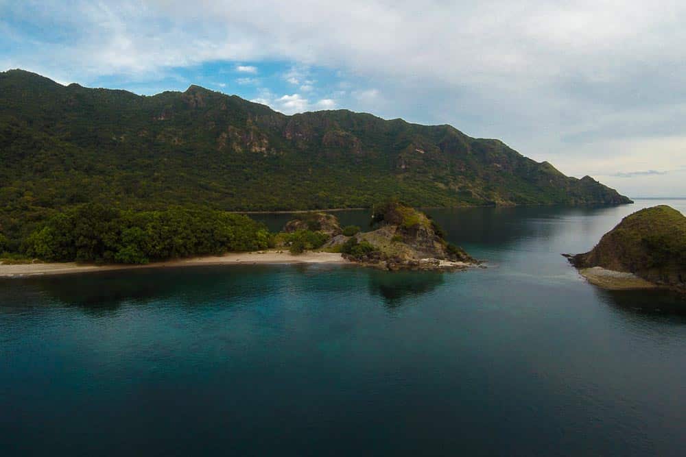 Coastline on a mountainous island covered in green forests and surrounding waters
