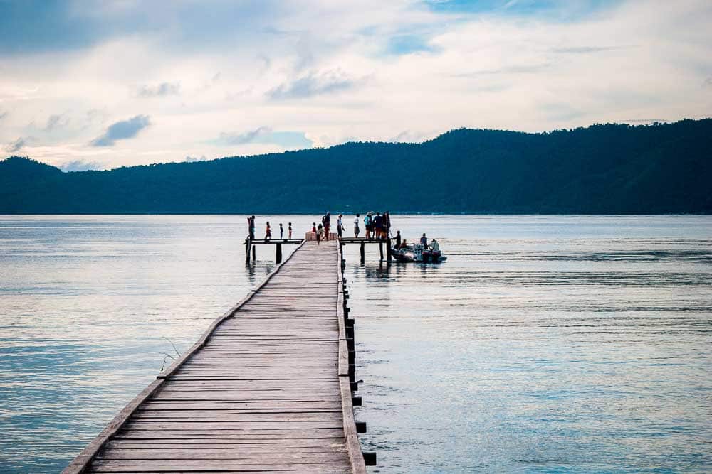 Yacht charter clients standing on the wooden pier in Sauwandarek, with a RIB anchored next to it