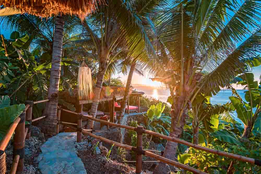 Narrow path to a secluded spot with sun beds near Villa Rahasia in Nihi luxury resort at sunset