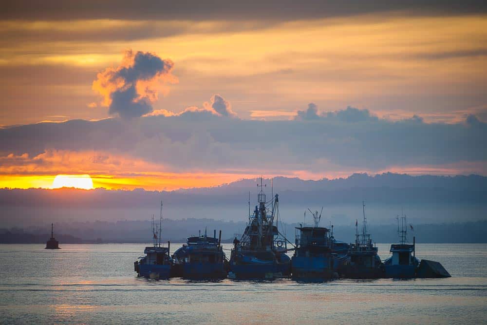Fishing boats anchored at sunset near Sorong's harbor