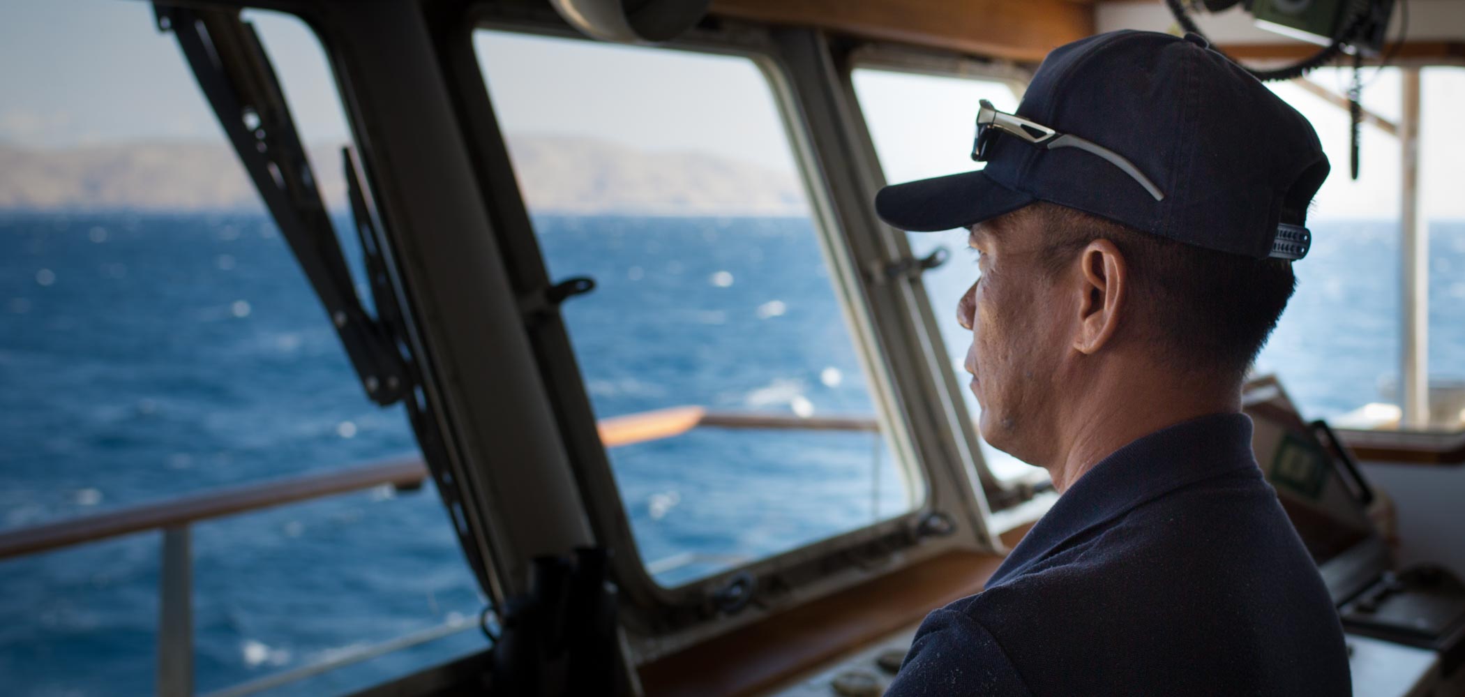 Captain Wayan looking out of the window on the bridge of Kudanil Explorer